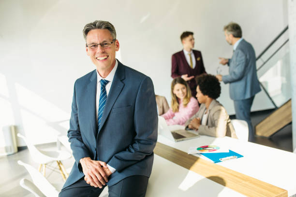 istock Senior businessman CEO sitting on the desk 1257357148