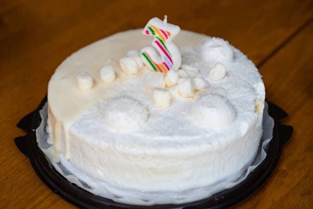 istock white birthday cake with candle number three. 1257357481