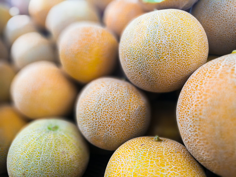 Color image depicting a large display of honeydew melons for sale at a fresh fruit and vegetable market. Room for copy space.