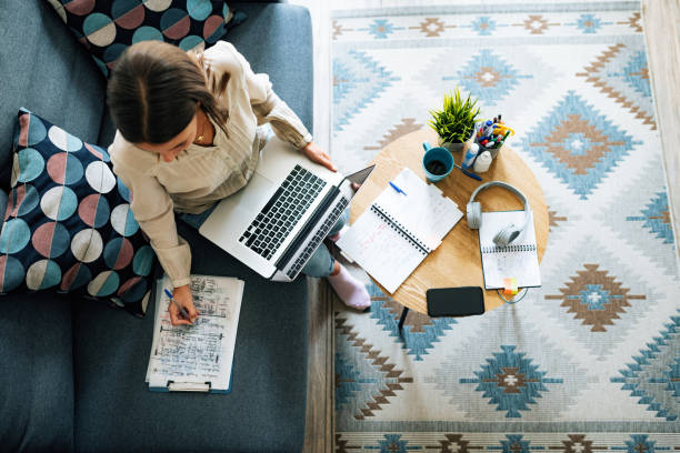 Young businesswoman at home having video call and telecommuting Portrait of modern woman at home teleconferencing with colleagues wide angle stock pictures, royalty-free photos & images