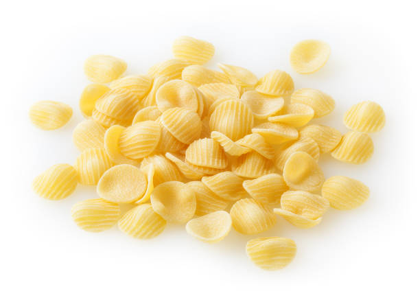 haufen von ungekochten orecchiette pasta isoliert auf weißem hintergrund - orecchiette stock-fotos und bilder