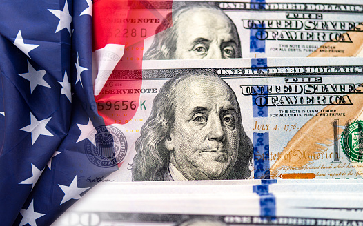 USA American flag and 100 dollars banknotes as background, concept picture about economy