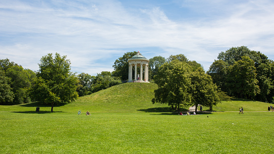 Munich, Bavaria / Germany - July 13, 2020: Panorama with the Monopteros. A greek stlye round temple located inside the Englischer Garten.