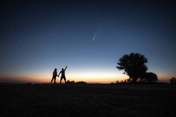 istock Young couple watching the Neowise comet under the bright night sky 1257361367