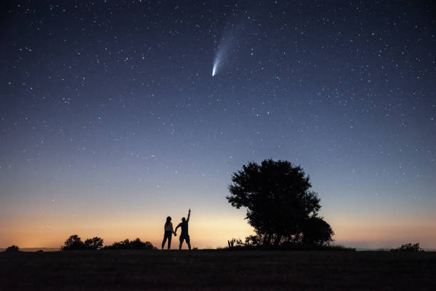 istock Young couple watching the Neowise comet under the bright night sky 1257361368