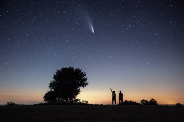istock Young couple watching the Neowise comet under the bright night sky 1257361373
