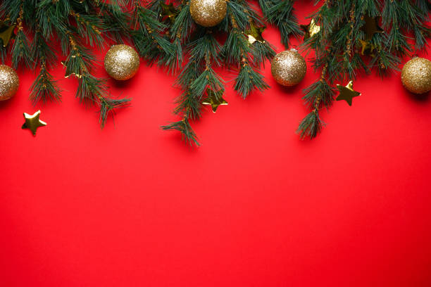 istock Christmas Tree Branches with toys on a red background with space for text 1257362611