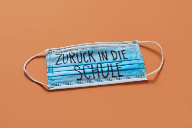 istock surgical mask and text back to school in german 1257366373