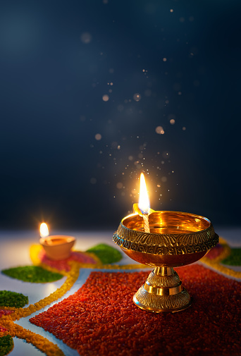 Happy Diwali, Glittering diya oil lamp against dark background with copy space