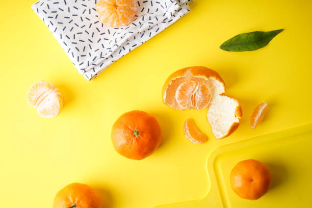 istock Fresh and ripe tangerines on a yellow background with a kitchen towel and a kitchen board. 1257375563
