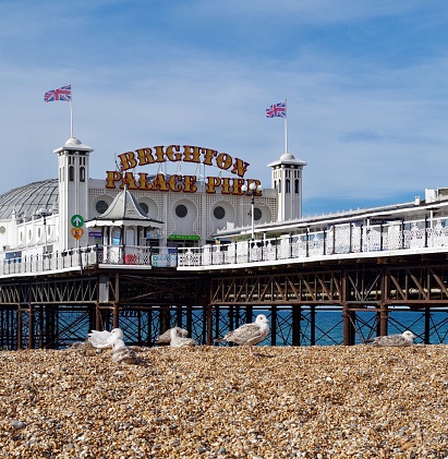 Views of the pier in Brighton on a sunny summers morning. The pier is shot from underneath for a different perspective. Brighton Palace Pier Opened in 1899 and home to fairground rides, bars, restaurants and deckchairs to enjoy the sea view.