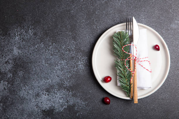 istock Christmas table with a plate, fork, knife, Christmas tree branches and Christmas decorations. top view, copy space 1257380609