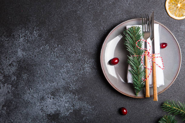 istock Christmas table with a plate, fork, knife, Christmas tree branches and Christmas decorations. top view, copy space 1257380630