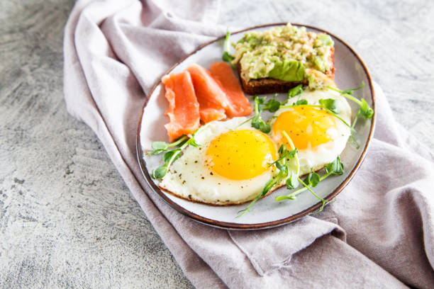 istock Egg breakfast. Healthy nutritious breakfast with eggs, salmon, avocado sandwich and sprouted pea seeds 1257380906