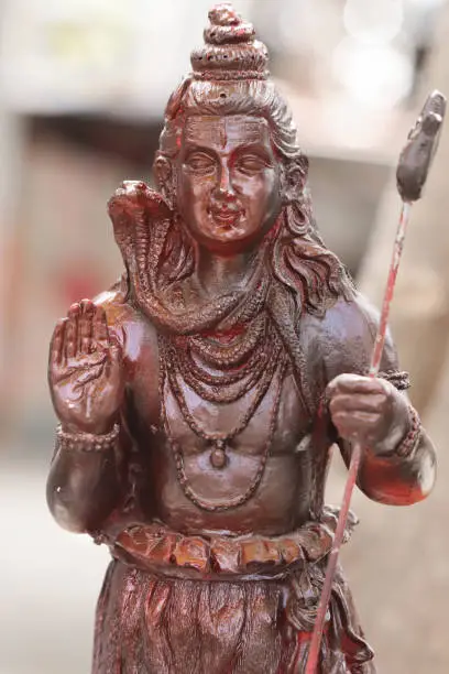 Photo of Colorful Beautiful Painted Handcrafted Statue Of Indian Hindu Lord Idol Shankar Shiva Bhagwan Om Namah Shivay God Of Destruction Har Har Mahadev With Damru Trishul And Snake Made Of Earthenware Mud Clay Stone Or Rock For Worship Pooja Puja In Maha Shivara