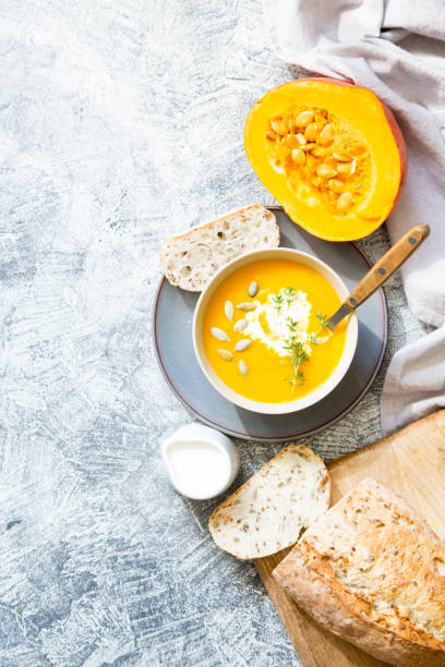 pumpkin soup with pumpkin seeds, crisp bread and thyme with copy space stock photo