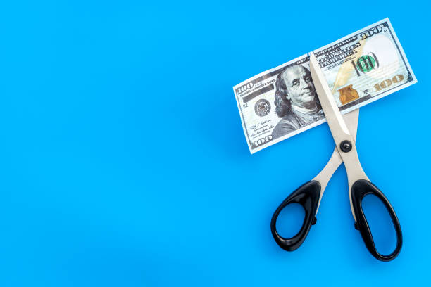 istock Decline of dollar exchange rate. Scissors cut dollars banknote 1257384475