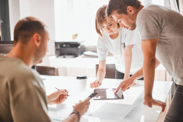istock Young creative team of designers is developing a new interior project in modern white studio 1257387070