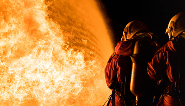 istock Firefighters use twirl water fog spraying down fire flame. 1257388391