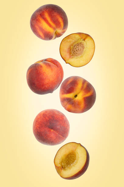 Falling peaches isolated on a color background with clipping path. Flying food, fruit