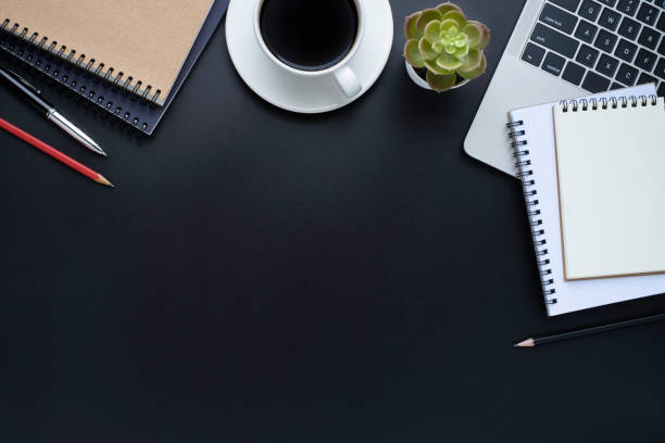 istock Black office desk table with laptop, notebook and coffee cup with equipment other office supplies. Business and finance concept. Workplace, Flat lay with blank copy space, Top view. 1257391908