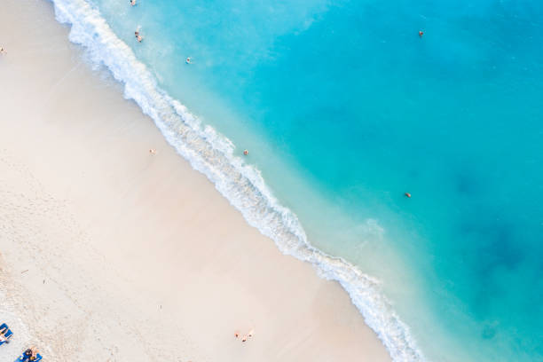 istock Beach scene from above - blue ocean waves hitting a sandy beach. 1257393849