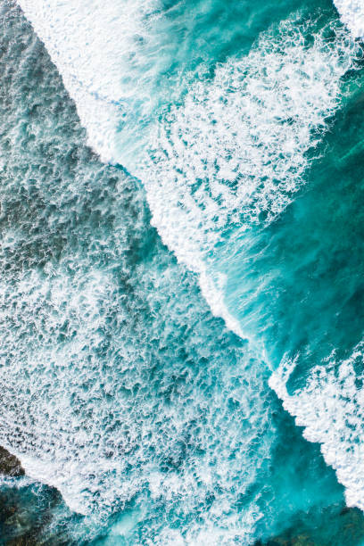 istock Big ocean waves hitting a coral reef. View from above. 1257393863