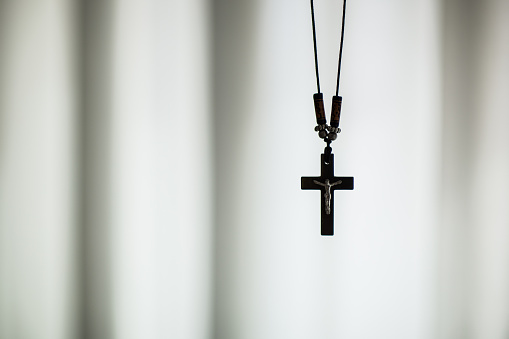 Christian necklace with a cross. Black and white isolated closeup.