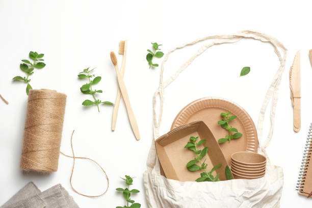 istock textile bag and disposable tableware from brown craft paper, green mint leaves on a whitebackground. View from above 1257395401
