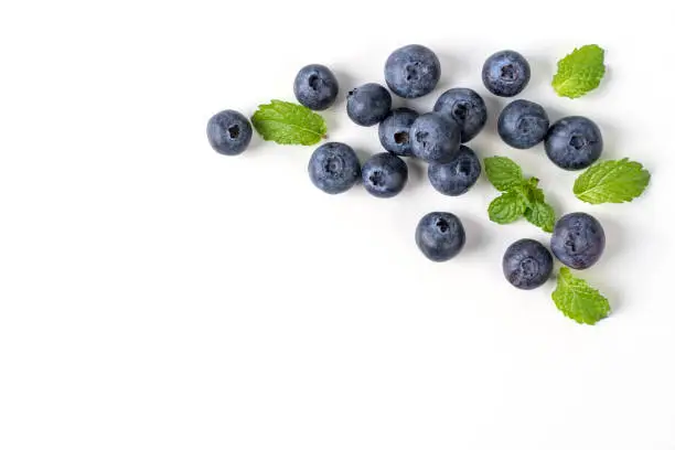 Photo of Blueberry fruit top view isolated on a white background, flat lay overhead layout with mint leaf.