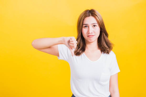 istock woman unhappy, a negative gesture showing finger thumbs down 1257398290