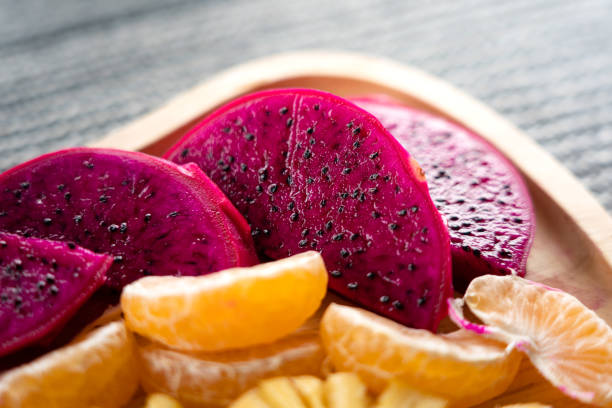 A plate of fruits set is served for breakfast meal. Close-up and selective focus at the Dragon fruits piece.