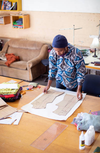 istock An African fashion designer cutting pattern paper at work in their studio. 1257403110
