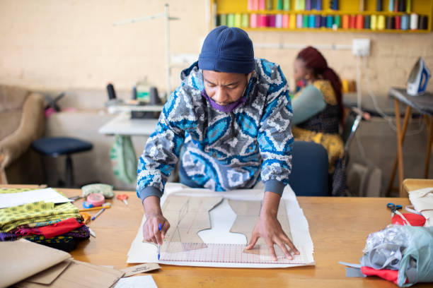 istock An African fashion designer cutting pattern paper at work in their studio. 1257403369