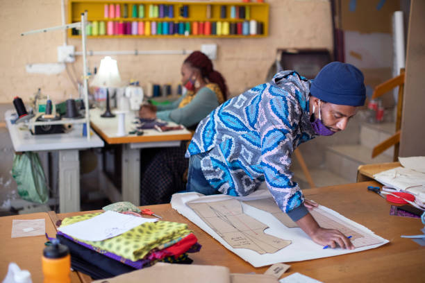 istock An African fashion designer cutting pattern paper at work in their studio. 1257403461