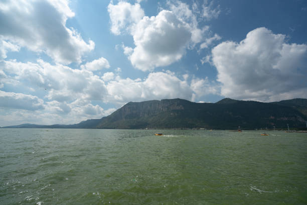 существует водная особенность гор на расстоянии от солнца. - standing water water coastal feature the natural world стоковые фото и изображения