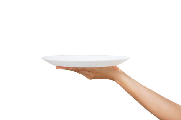 istock White plate on hand woman on white 1257404878