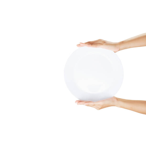 istock White plate on hand woman on white 1257404888
