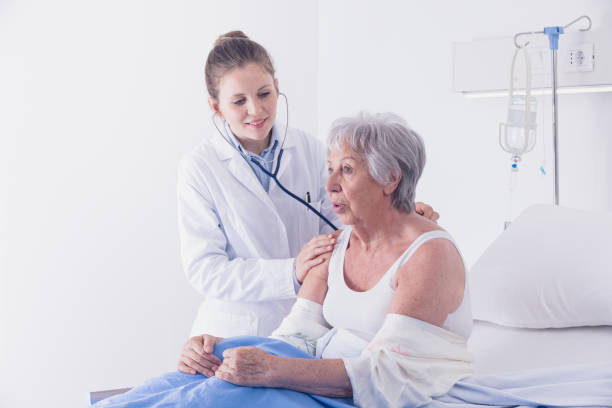 médico femenino que escucha los pulmones de los pacientes - bed hospital prognosis patient fotografías e imágenes de stock