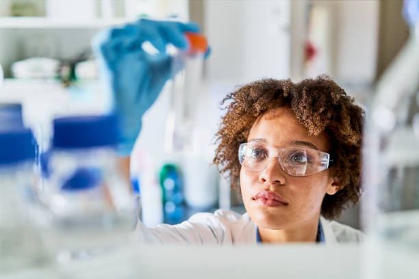Young scientist holding up a research sample in a lab