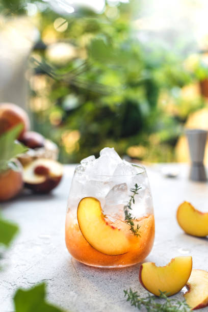 istock Summer refreshing ice cocktail with peach slice and thyme 1257408807