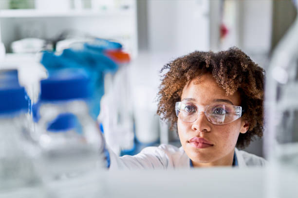 istock Young scientist taking a research sample from a shelf in a lab 1257408819