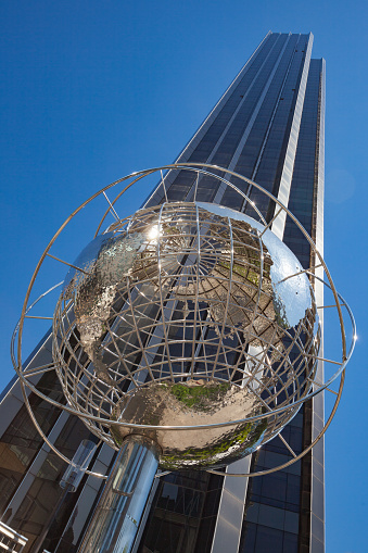 New York, United States - May 05, 2010: A steel globe created by Kim Brandell and located at the Columbus Circle subway station on 59th street. In the background can be seen a Trump Tower (owned by Donald Trump), a 68-story mixed-use skyscraper located at 725 Fifth Avenue between East 56th Street and East 57th Street in Midtown Manhattan, New York City.
