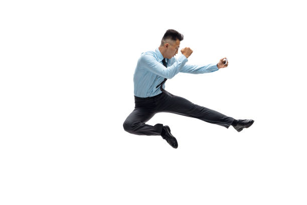 istock Man in office clothes practicing taekwondo on white background. Unusual look for businessman in motion, action. Sport, healthy lifestyle. 1257411654