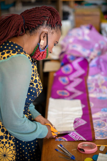 istock An African woman cutting patterns in fabric in her studio. 1257413501