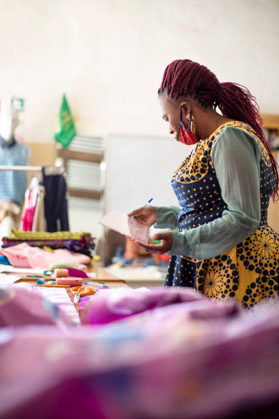 istock An African woman cutting patterns in fabric in her studio. 1257413864