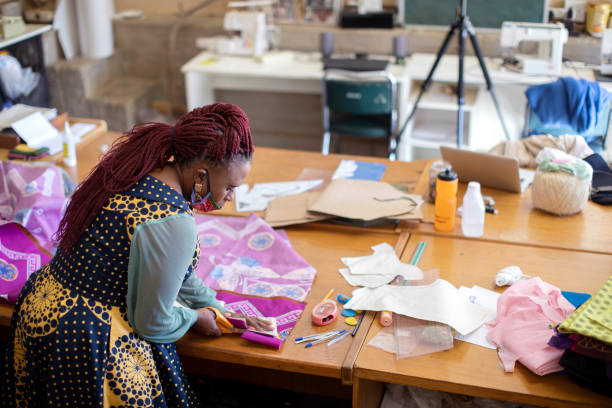 istock An African woman cutting patterns in fabric in her studio. 1257413878