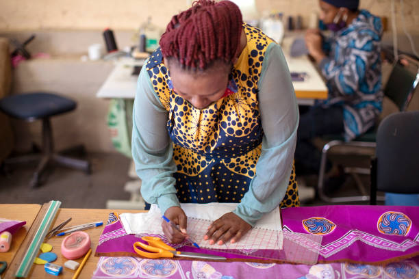 istock An African woman cutting patterns in fabric in her studio. 1257413886