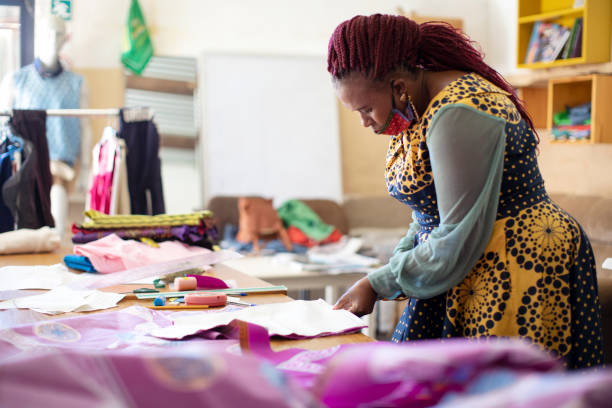 istock An African woman cutting patterns in fabric in her studio. 1257413887