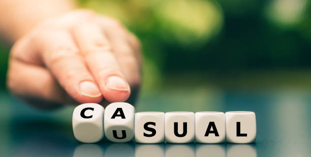 istock Hand turns dice and changes the word usual to casual. 1257413892